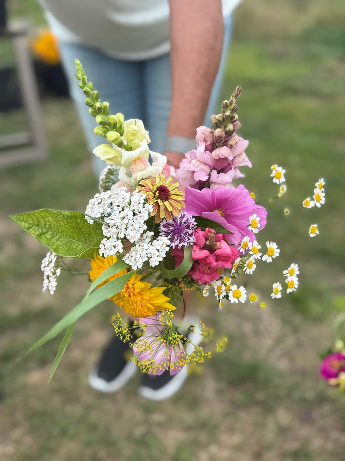 Iemand houdt een kleurrijk boeket vast in het veld